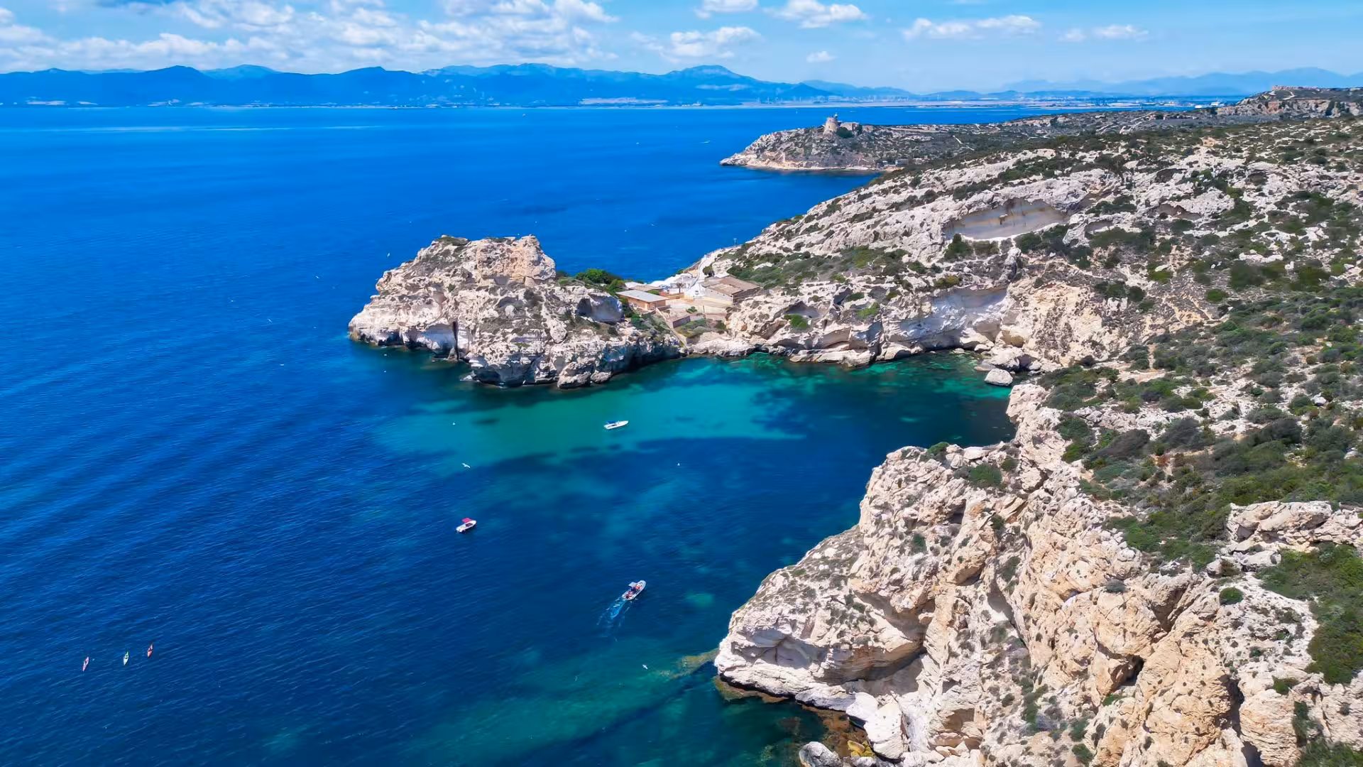 Discover stunning cliffs and azure waters of Cagliari's coastline on an exhilarating dinghy adventure.