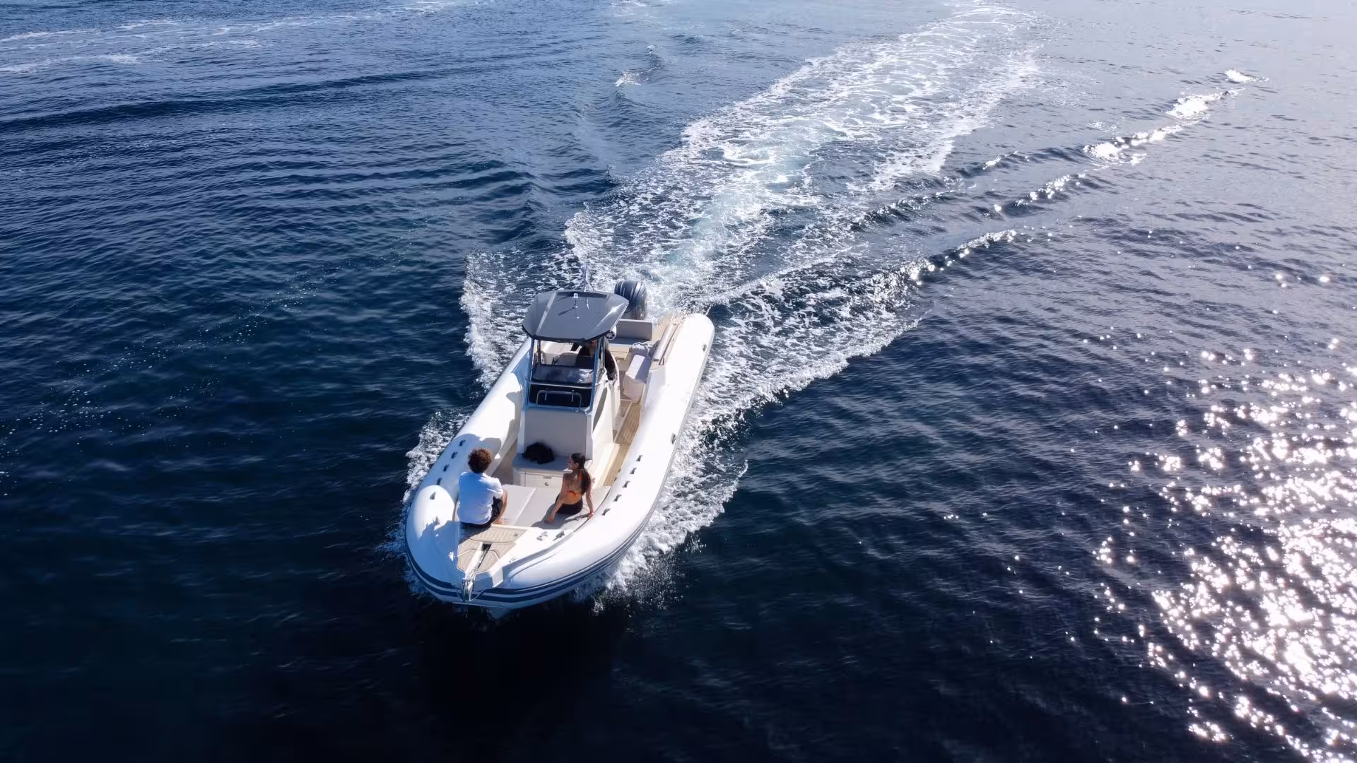 Aerial view of a dinghy cruising through clear blue waters in the Gulf of Angels, Cagliari, ideal for a scenic tour.