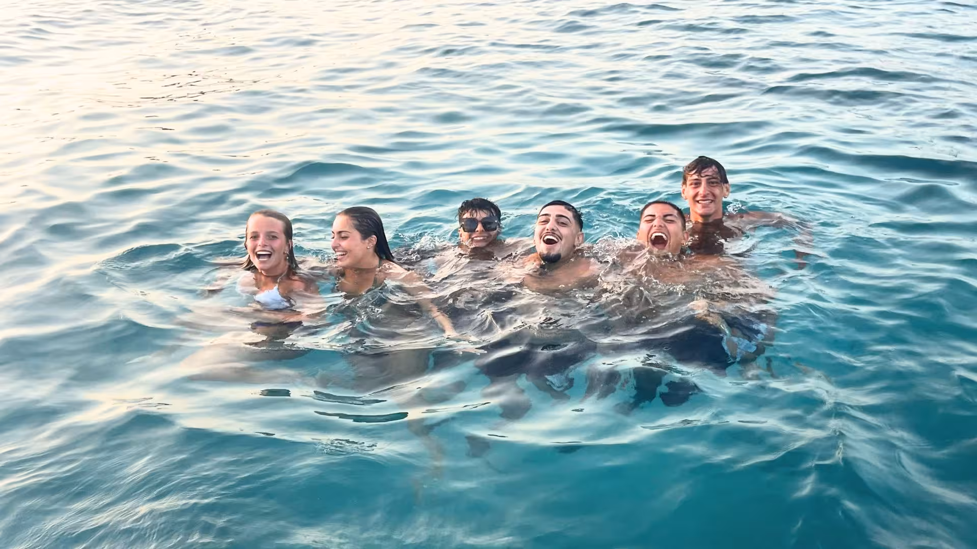 Group enjoying snorkeling in the clear turquoise waters of Cagliari during a fun-filled dinghy tour.