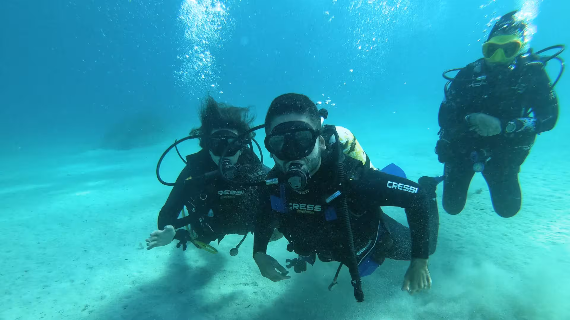 Two scuba divers exploring the vibrant underwater world of the Gulf of Angels in Cagliari.
