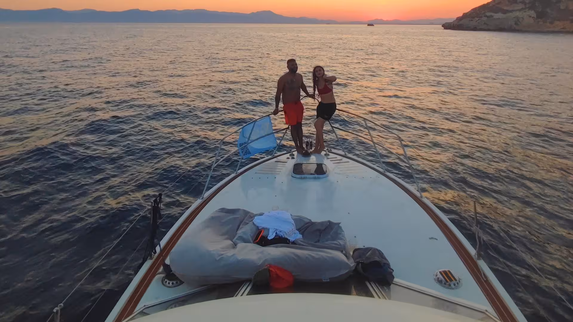Couple enjoying sunset on a boat tour in the Gulf of Angels, Cagliari, with stunning sea views.