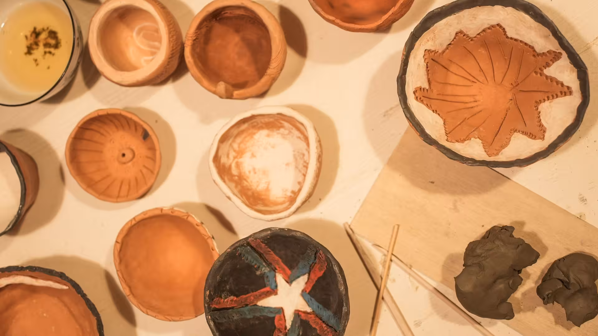 Assorted handcrafted ceramic bowls with intricate designs displayed at a Cagliari ceramics workshop.