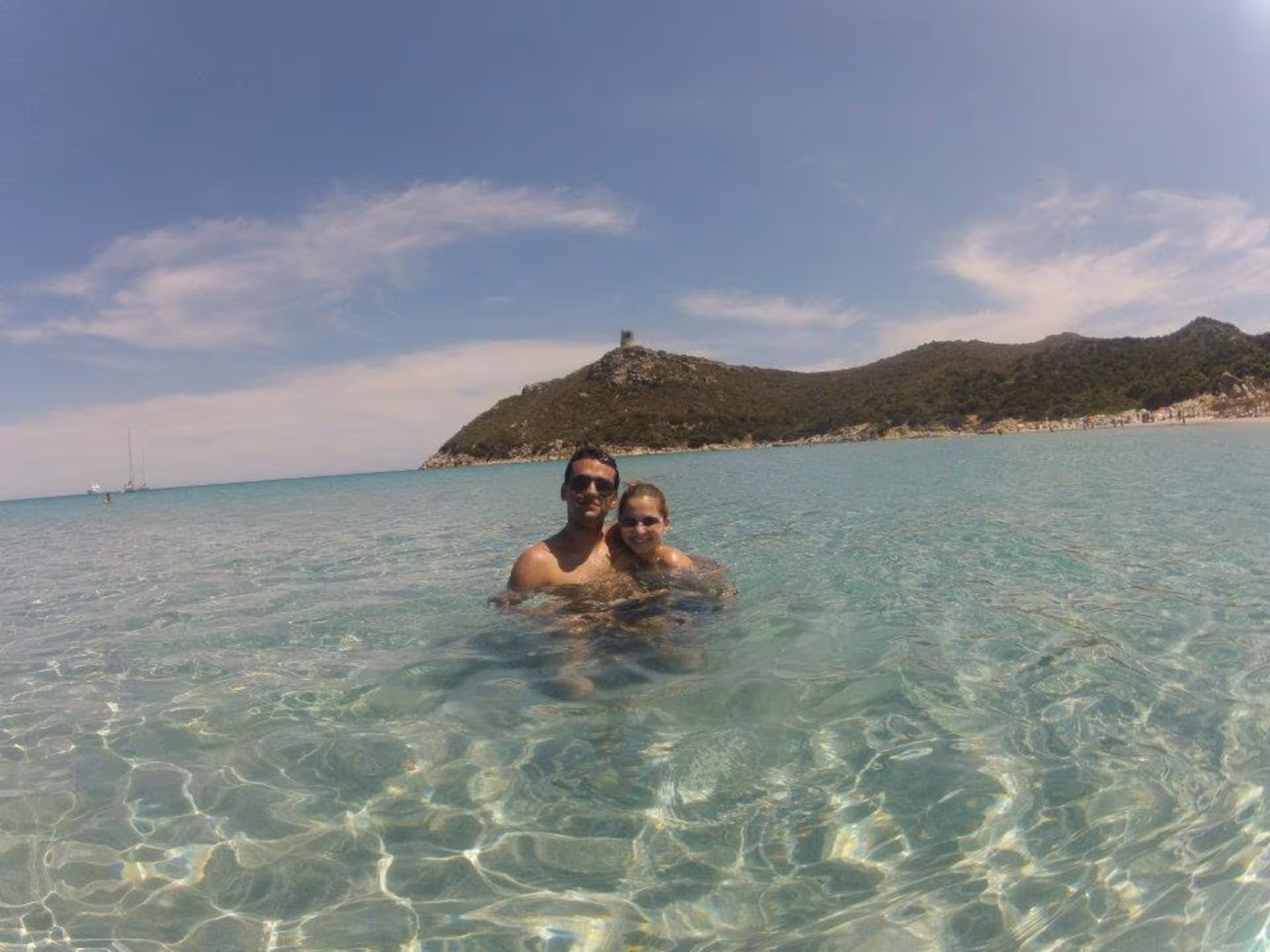Couple enjoying the crystal-clear waters of Chia beach during a jeep tour from Cagliari, Sardinia.