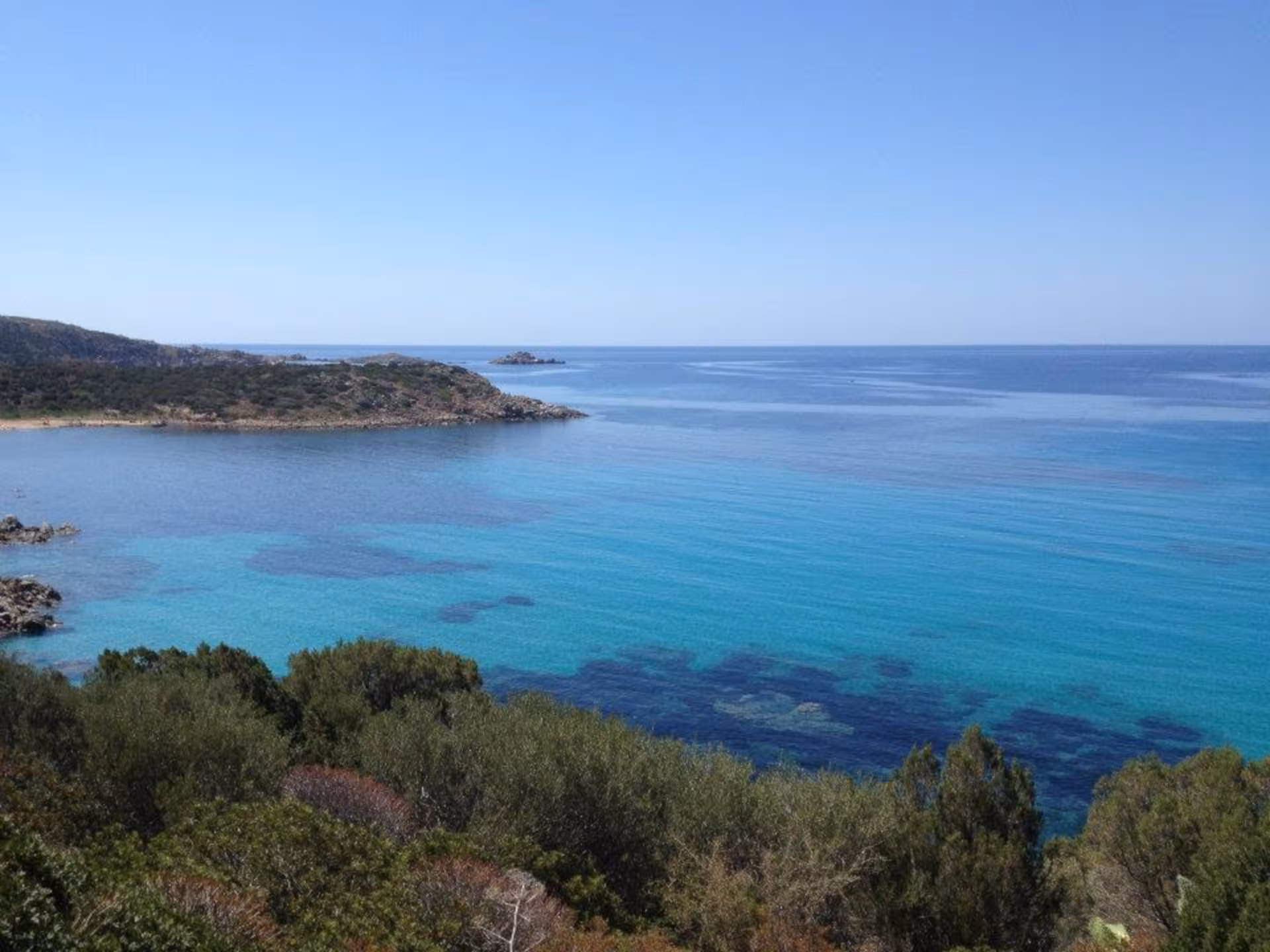 Pristine coastal landscape of Chia with clear blue waters and lush greenery, perfect for exploration from Cagliari.