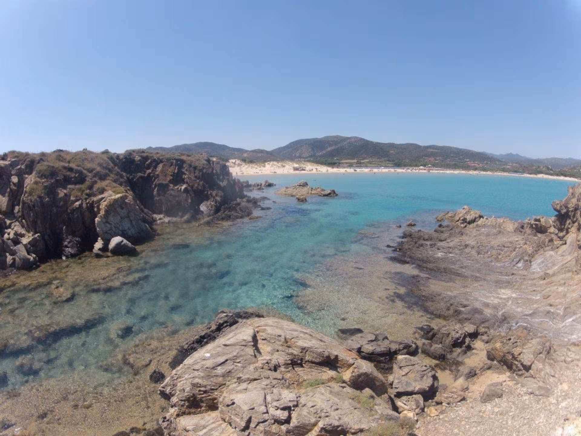 Scenic view of Chia's rugged coastline with turquoise waters, ideal for exploration on a Cagliari jeep tour.