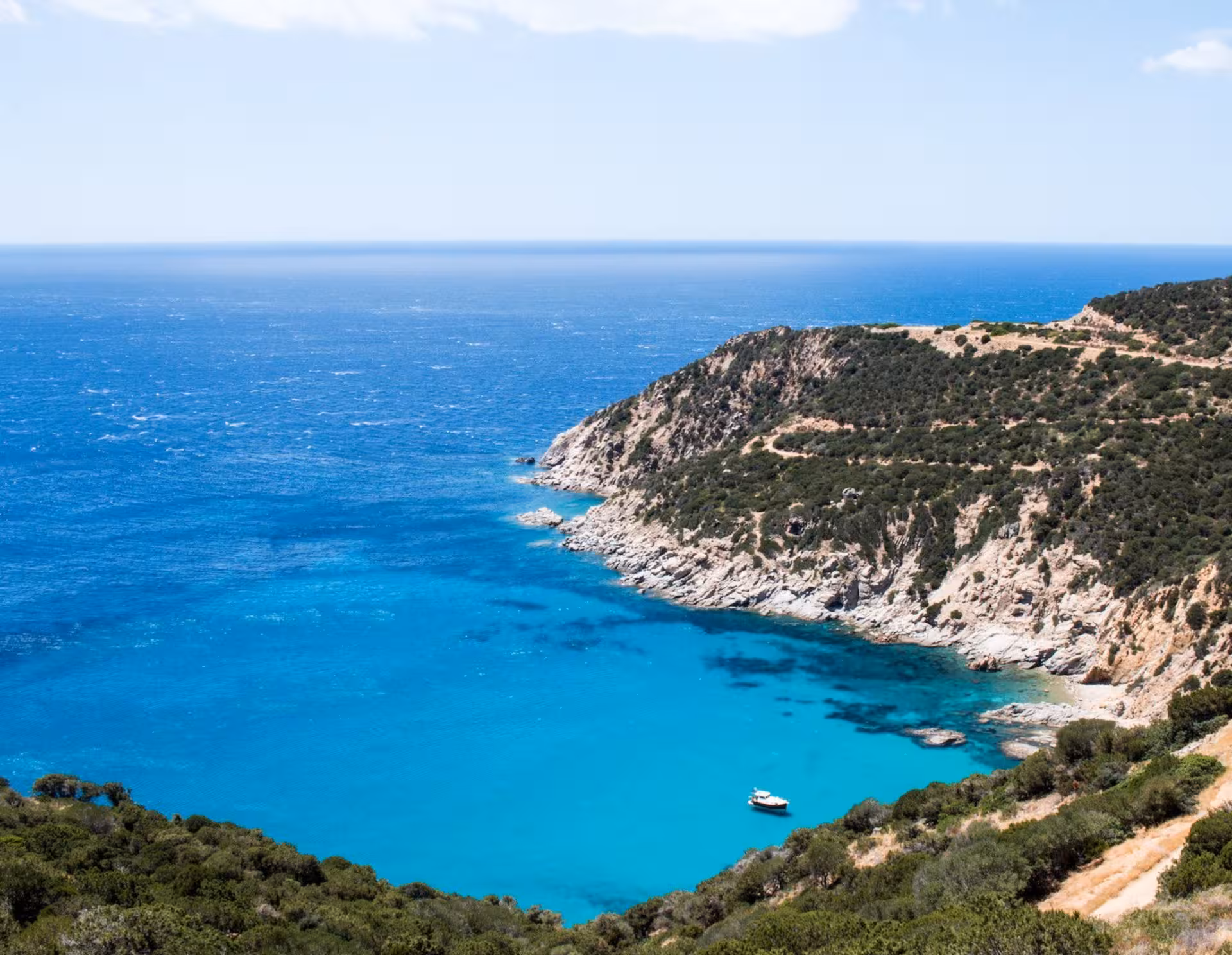 Aerial view of the stunning turquoise waters and rugged coastline of Villasimius, perfect for a Cagliari jeep tour.
