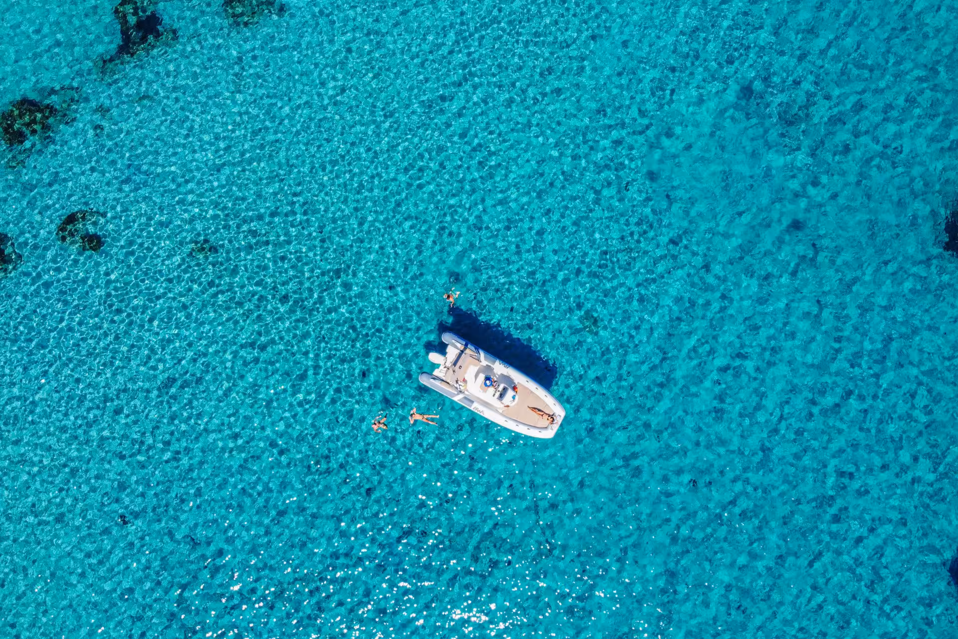Aerial view of a RIB boat surrounded by crystal-clear turquoise waters in Cagliari, perfect for a scenic tour.