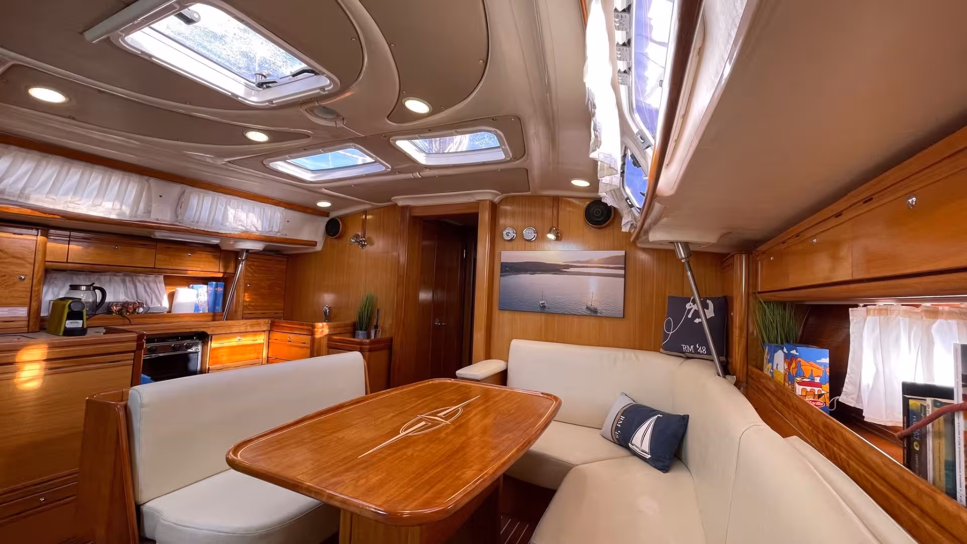 Luxurious interior of a sailing boat on a Cagliari tour, featuring elegant wood finishes and comfortable seating.