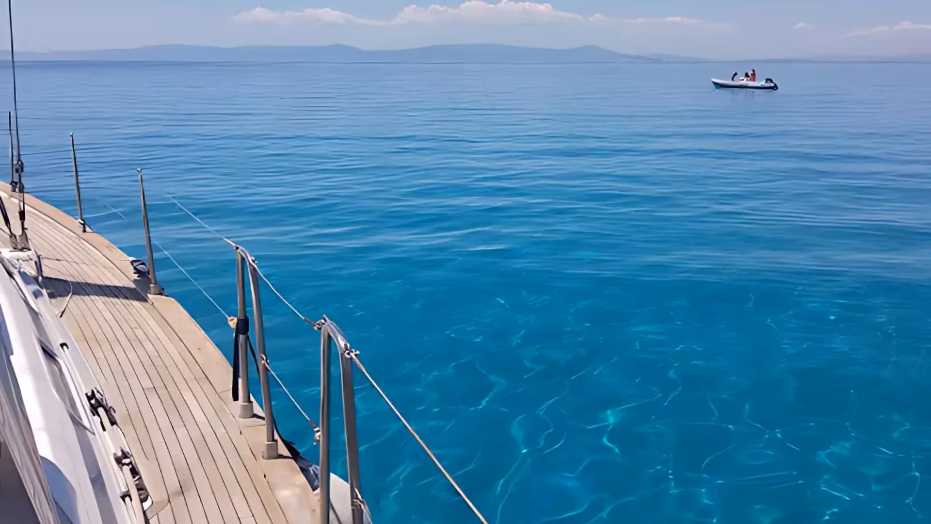 Clear turquoise waters and distant mountains seen from a sailing boat on a Cagliari 5-hour tour.