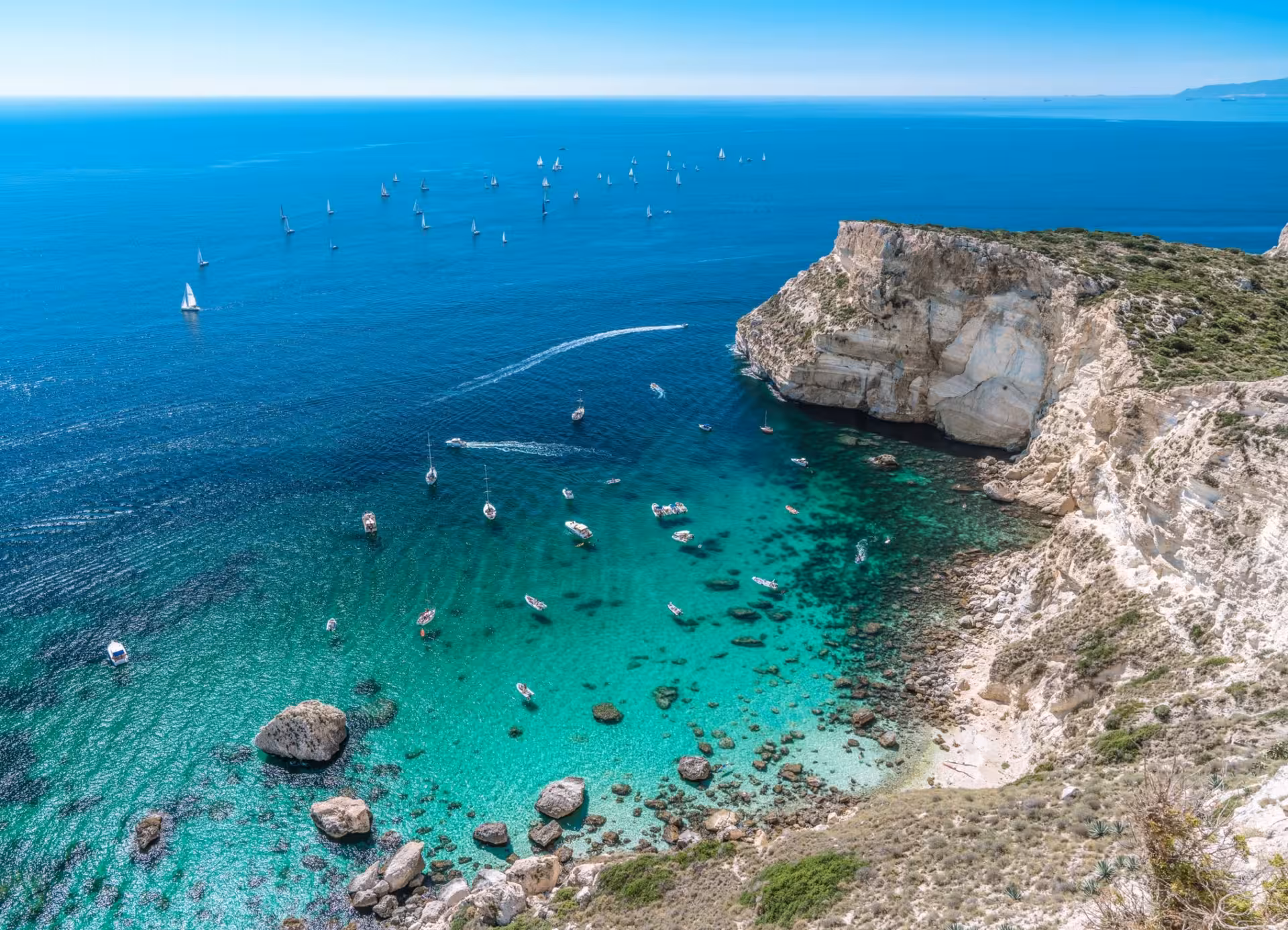 Stunning aerial view of Cagliari's clear turquoise waters and rocky cliffs, perfect for a 5-hour sailing tour.