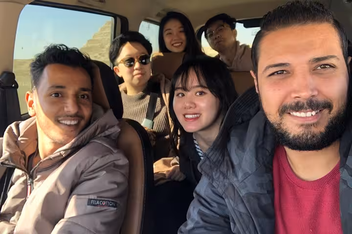 Travelers in private car on Cairo Airport layover tour, heading to Giza Pyramids and Grand Egyptian Museum