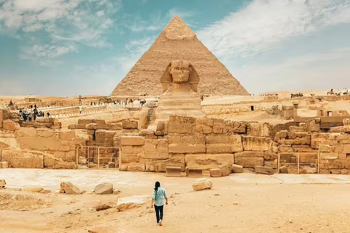 Traveler walking toward the Sphinx and Giza Pyramid on a Cairo Airport layover tour with guided stopover