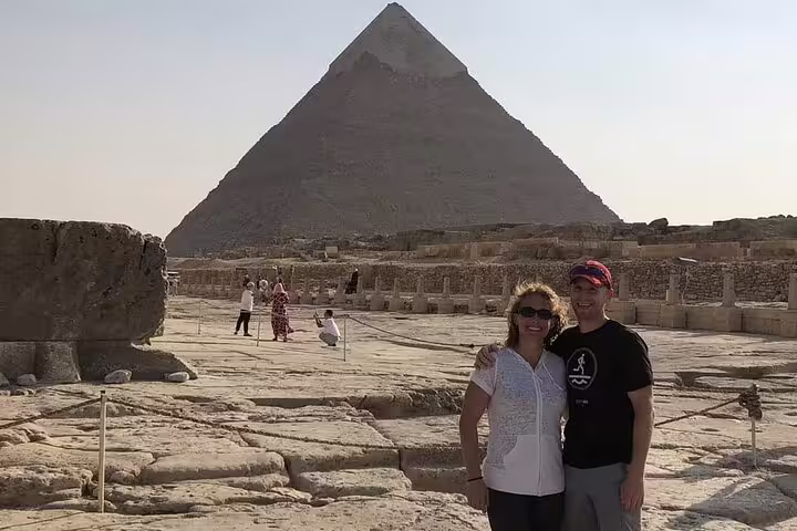 Couple photo at Giza Plateau with the Great Pyramid on a Cairo Airport layover tour to Giza Pyramids and Sphinx