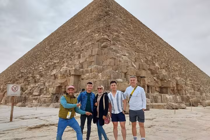 Travelers and guide at Great Pyramid of Giza on Cairo Airport private transfer tour and sightseeing