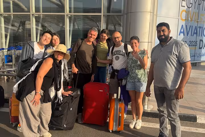 Group of tourists with luggage meeting driver at Cairo International Airport for private transfer to Cairo Giza