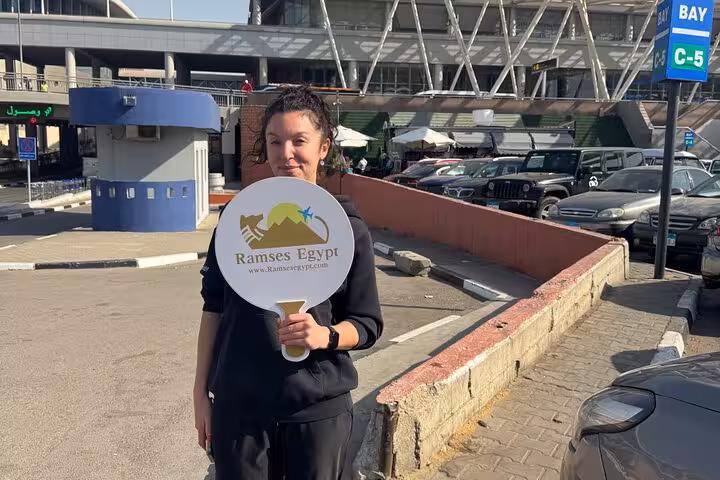 Meet-and-greet staff holding Ramses Egypt sign at Cairo International Airport for private transfer to Giza