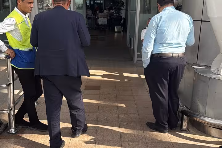 Airport staff and driver coordinating pickup at Cairo International Airport terminal for private Cairo Giza transfer