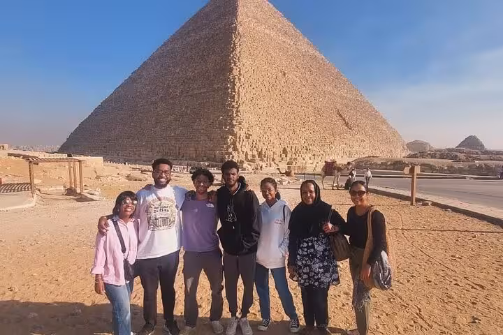 Private Cairo Airport tour group photo at Great Pyramid of Giza on pyramids museum and Coptic Cairo trip