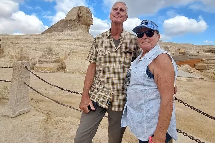 Couple posing by the Great Sphinx of Giza on a private Cairo Airport day trip to pyramids and Egyptian Museum