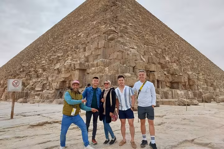 Private Cairo Airport tour group photo at the Great Pyramid of Giza with guide, Egypt day trip