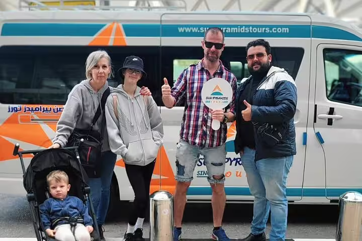 Family and driver posing by Cairo Airport transfer minivan, safe private pickup, luggage help and hotel drop-off