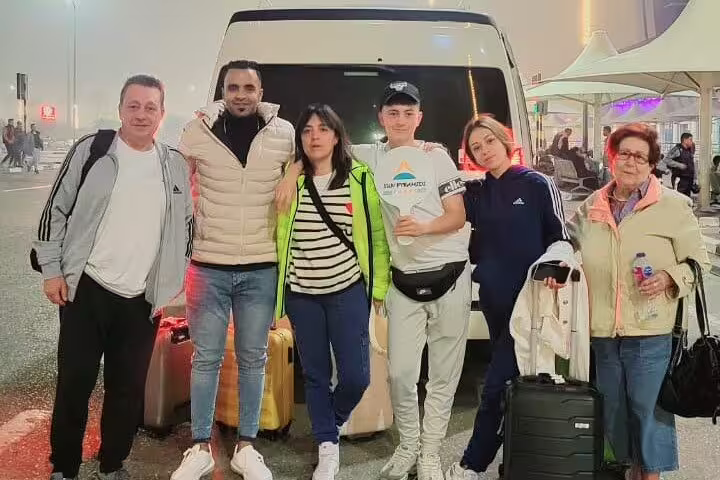 Family with suitcases beside private van at Cairo Airport, comfortable door-to-door Cairo transfer service