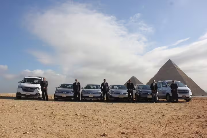 Fleet of private cars and vans for Cairo Airport transfer service with Giza Pyramids in the background