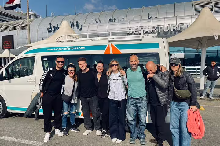 Group travelers beside shuttle van at Cairo Airport departures for reliable Cairo airport transfer pickup service