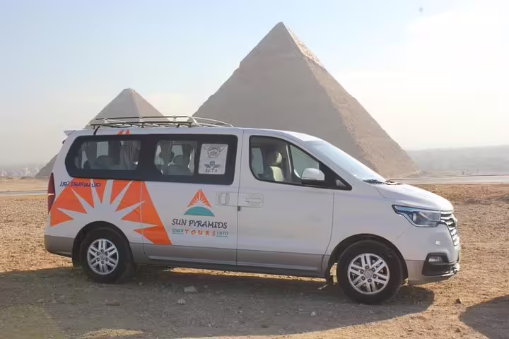 Modern air-conditioned van for Cairo Airport pickup and drop-off parked near the Giza Pyramids, Cairo