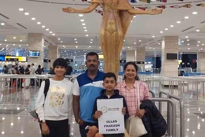 Family at Cairo airport arrival hall with VIP meet and assist service sign for international transfer.