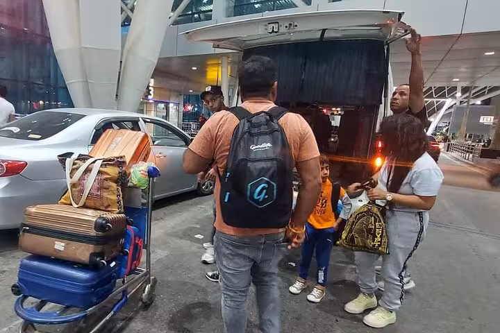 Travelers with luggage and a guide at Cairo airport for VIP meet and assist transfer service.