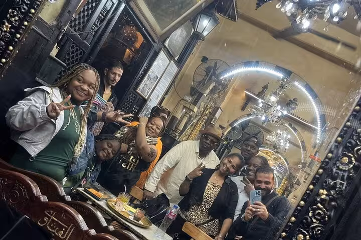 Group photo inside a historic Cairo bazaar cafe, exploring hidden gems, local cuisine, and culture