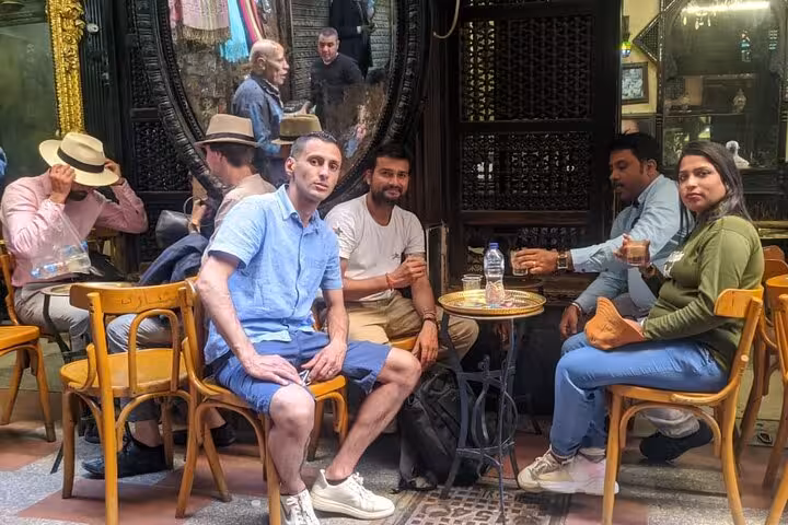 Visitors enjoy traditional tea at a bustling Cairo bazaar, highlighting local culture on the Egypt private tour.