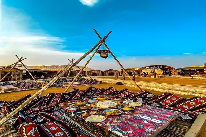 Traditional Bedouin dinner setup in Giza desert camp for VIP Arabian Night show, carpets and shared plates