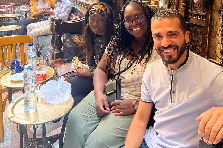 Guests relax at a traditional Cairo cafe tasting local bites on a hidden gems culture and cuisine tour