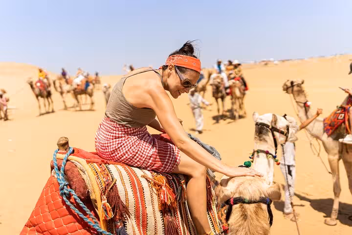 Traveler enjoying a camel ride in the Giza desert on a Cairo full-day customized adventure tour