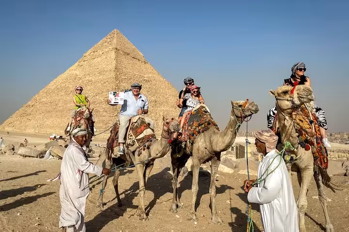 Camel ride at Giza Pyramids on a Cairo full-day customized adventure tour, with local guides and desert views
