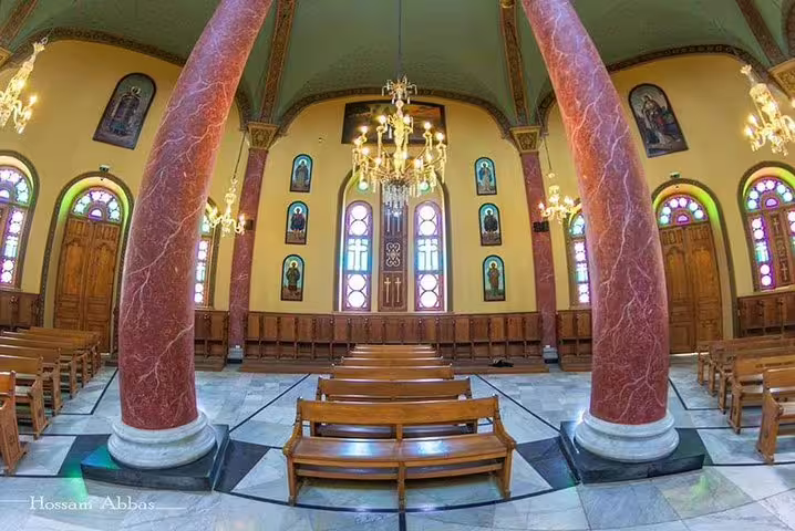 Cairo cathedral nave with marble columns, stained glass, and pews, part of Four Seasons luxury travel