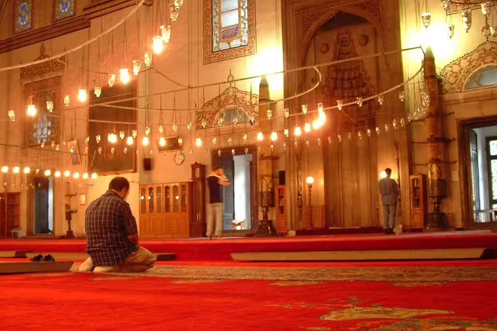 Interior of Cairo Citadel mosque with red prayer carpets and hanging lanterns on a guided day tour