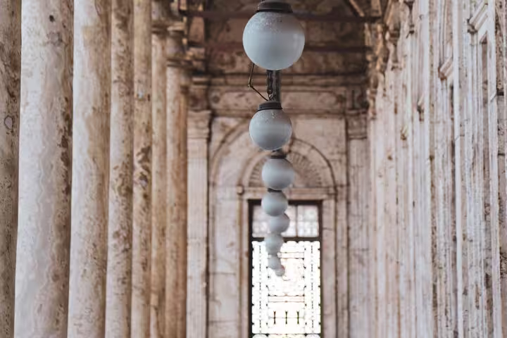 Historic stone colonnade with hanging lamps inside Cairo Citadel, part of National Museum and Egyptian Museum tour