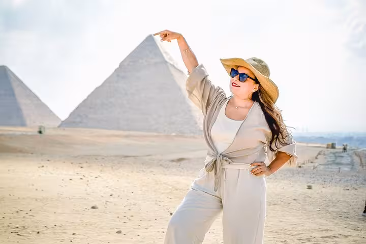 Traveler posing by the Giza Pyramids on a Cairo day tour by plane from Marsa Alam, Egypt highlights