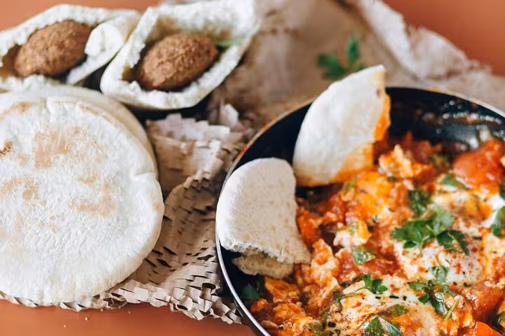 Experience authentic Cairo cuisine with falafel and shakshuka served with pita bread on the downtown food tour.