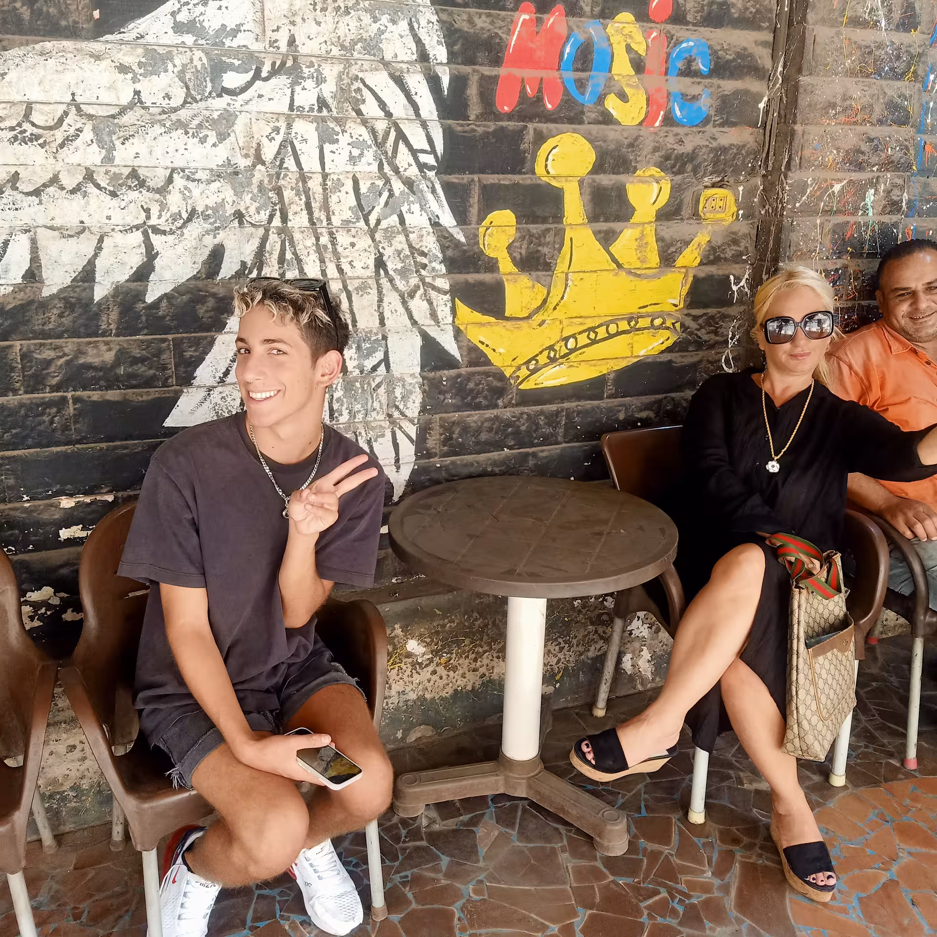 Tour guests relaxing at a Cairo cafe with colorful street art during a private Cairo food tour and funny walking tour