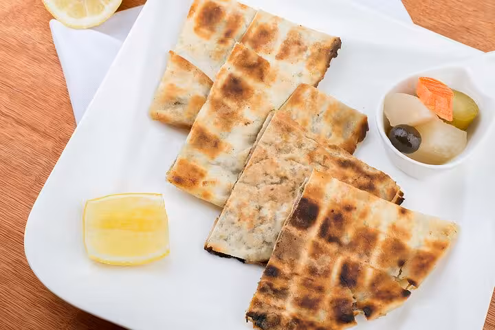 Indulge in traditional Egyptian hawawshi with pickled vegetables and lemon on the Cairo food adventure.