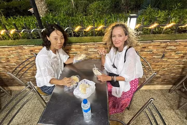 Travelers tasting local Cairo snacks at an outdoor café stop on a private Cairo food tour and funny walking tour