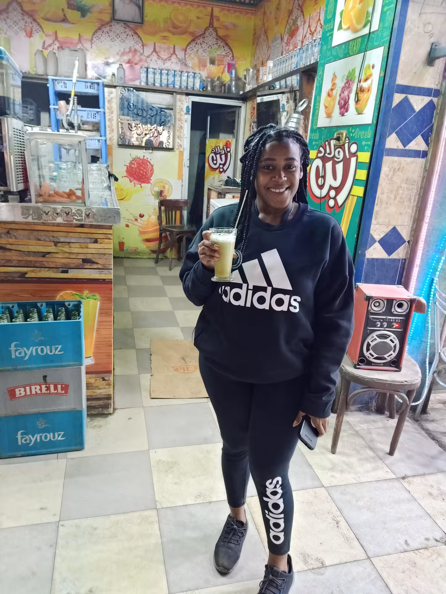 Guest holding fresh sugarcane juice inside a Cairo street shop during a private Cairo food tour walk