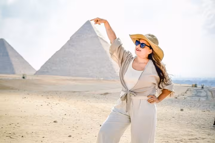 Traveler posing by the Giza Pyramids on a Cairo day trip tour to Pyramids, Saqqara and Memphis with lunch