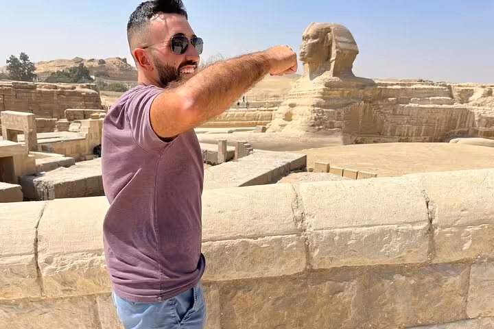 Tour guest posing with the Great Sphinx at Giza on a Cairo private pyramids tour with Egyptian lunch