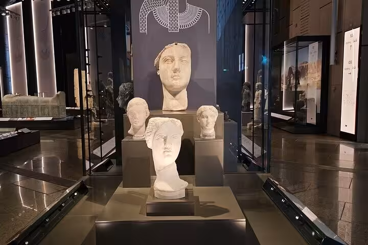 Ancient Egyptian statues inside the Grand Egyptian Museum, included in Cairo highlights tour with pyramids and museum