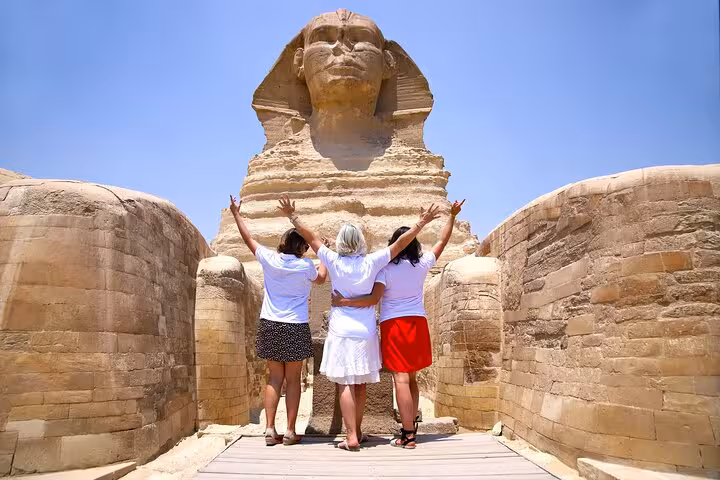 Travelers posing by the Great Sphinx of Giza on Cairo highlights tour with pyramids, Egyptian Museum and Nile cruise option
